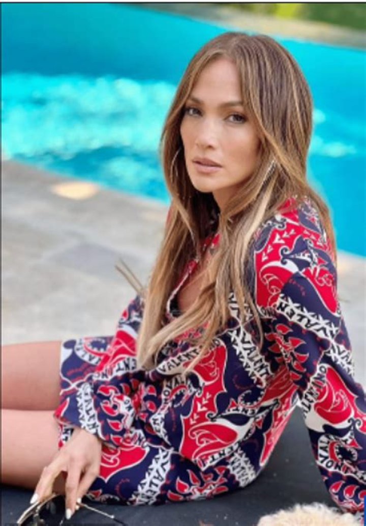 Jennifer Lopez lounges by the pool in a Valentino gown and hoop earrings